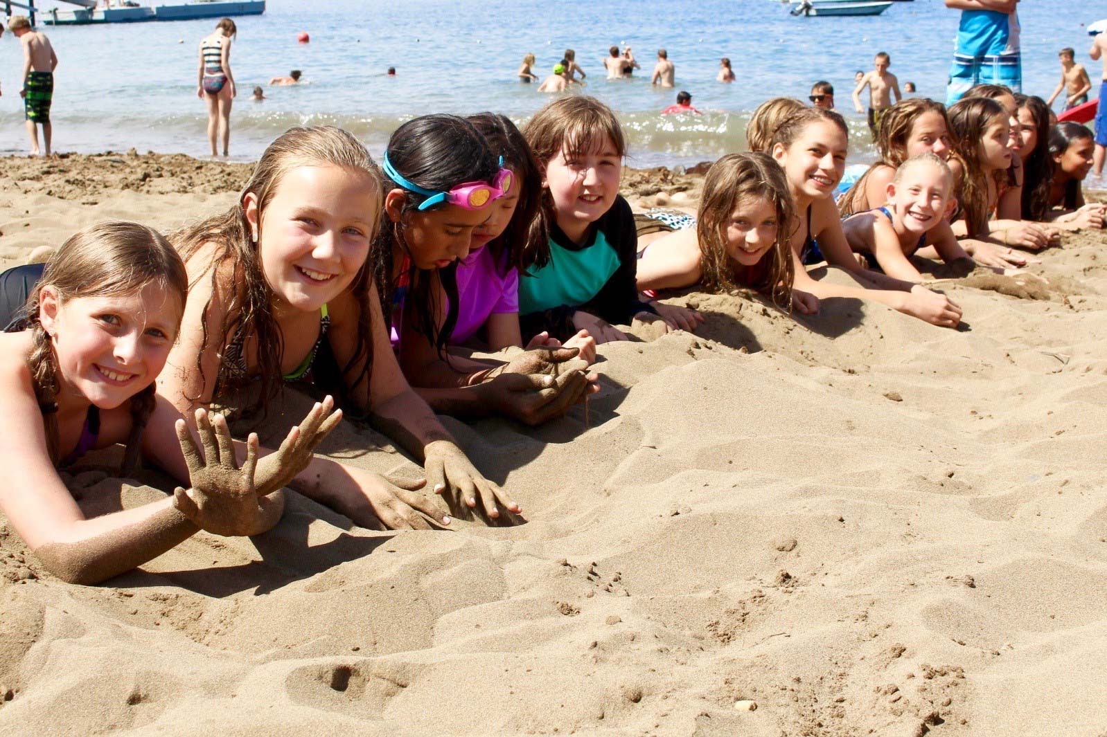A group of campers playing in the sand during a beach party.