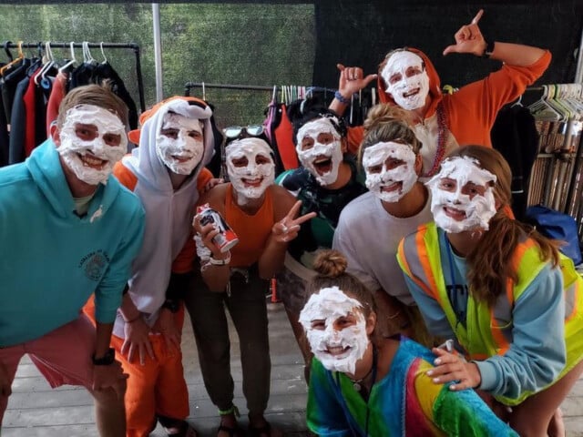 A group of campers and staff with cream on their faces.