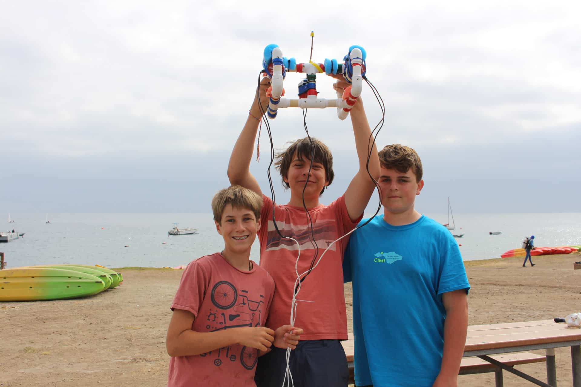Three campers at a beach with a ROV.