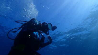 A scuba diver holding a camera.