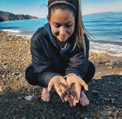 A staff member holding a starfish.