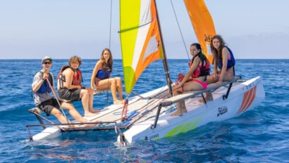 Campers steer sailboats across Toyon Bay at Catalina Sea Camp, learning teamwork and basic sailing skills in calm island waters.